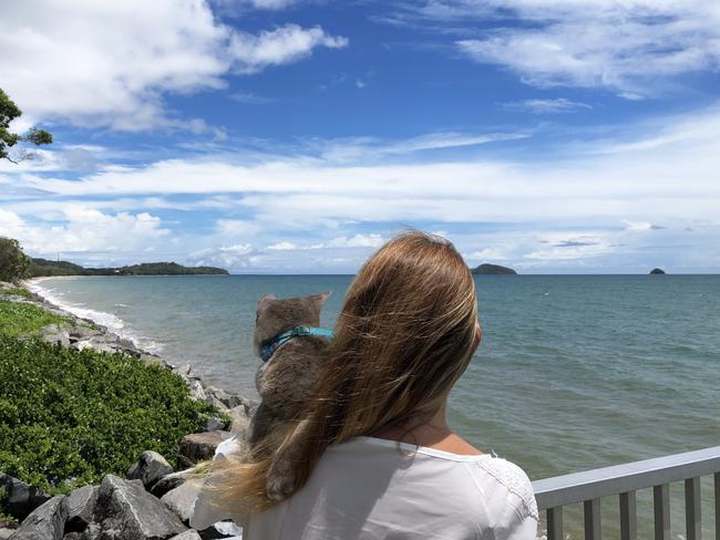 Carla at Clifton Beach near Cairns, Far North Queensland with Backer the grey rescue kitty. Picture: Supplied