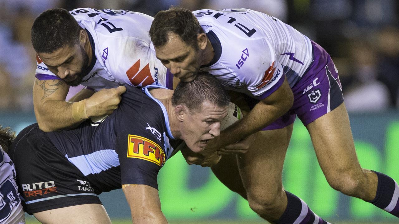 Paul Gallen of the Sharks is tackled by Jesse Bromwich and Cameron Smith.