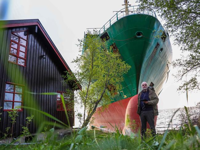 Johan Helberg outside his home with the enormous container ship NCL Salten just metres away. Picture: Jan Langhaug / NTB / AFP