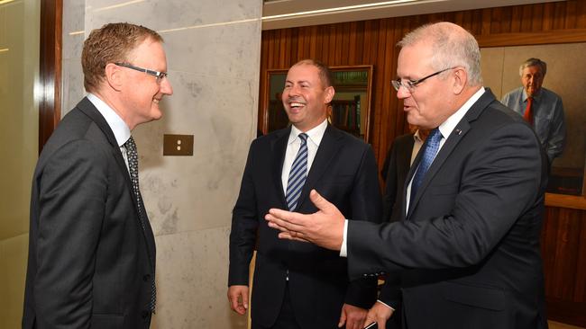 Prime Minister Scott Morrison and Treasurer Josh Frydenberg, centre, with Reserve Bank governor Philip Lowe, left, at the RBA in Sydney yesterday. Picture: AAP