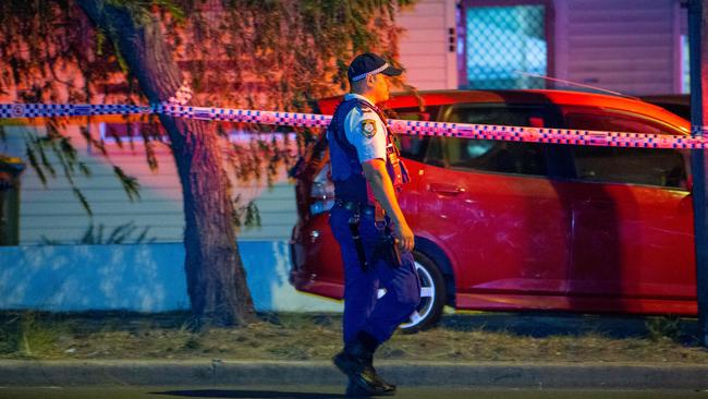 An officers examines the scene at Roberts Rd, Greenacre. Picture: Dean Asher