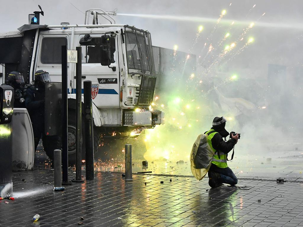 Fireworks explode on French riot police vehicles launched by protesters. Picture: Georges Gobet/ AFP