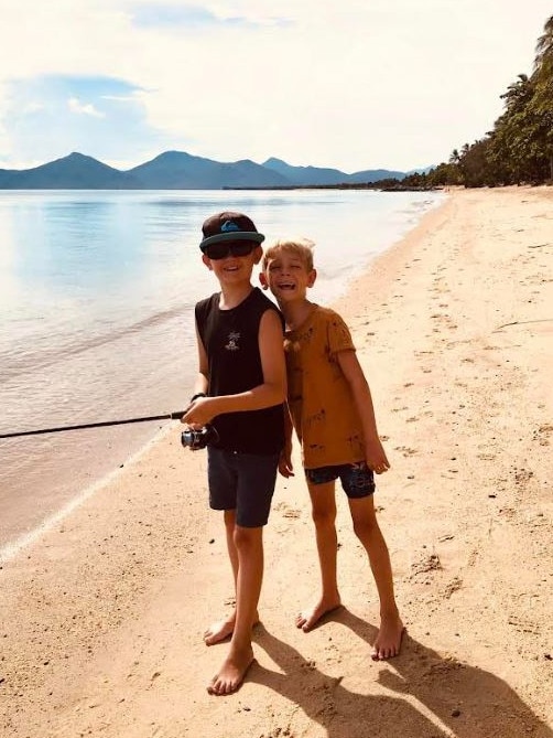 Cooper, pictured before he needed to wear a snow boot to manage his symptoms, fishing with his brother Dylan.