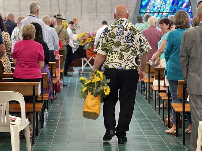 Fay's husband Dennis Cheal carried her iconic yellow crocodile handbag down the aisle, full of her favourite sunflowers. Picture: Fia Walsh