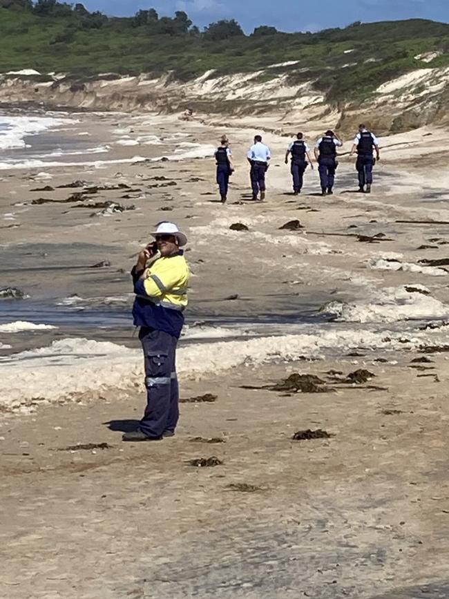 Police scour the beach where a body was found.