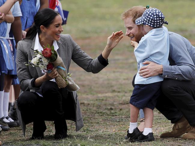 Meghan watches on as Harry is embraced by Luke Vincent, 5, on their arrival in Dubbo. Picture: Phil Noble/AP