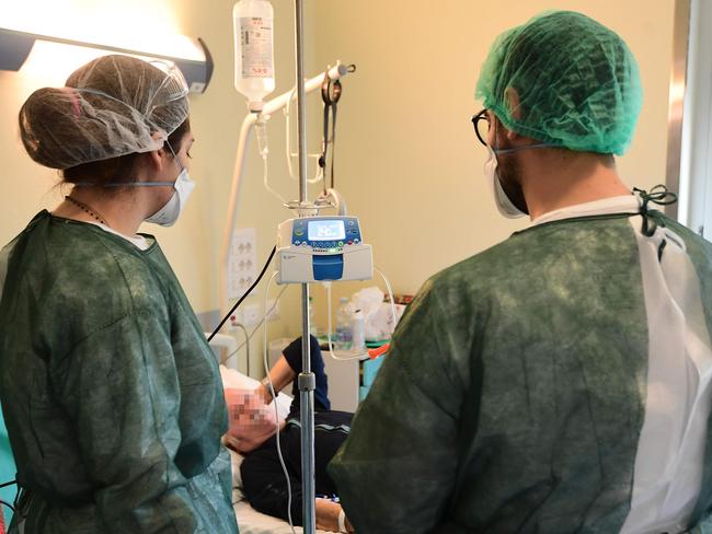 Healthcare workers talk with a patient recovering from COVID-19 at the Maggiore Hospital of Crema, southeast of Milan, on May 15, 2020. More than 30,000 people in Italy have died as a result of the virus. Photo: Miguel Medina/AFP