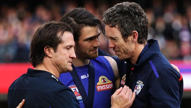 Western Bulldogs coach Luke Beveridge, Captain Easton Wood and Robert Murphy hug on stage after the Bulldogs won the AFL Grand Final.