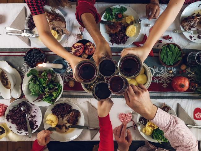 overhead view on family sitting around christmas table with traditional Christmas roast