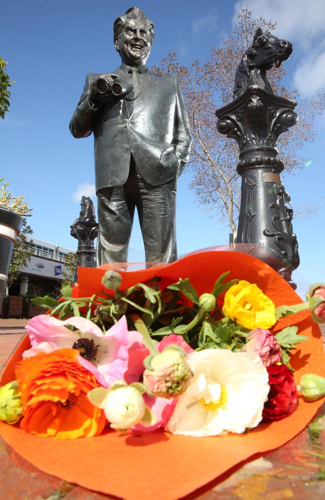 Flowers rest alongside the statue of Bart Cummings at Flemington racecourse on Sunday. Picture: Brendan Francis