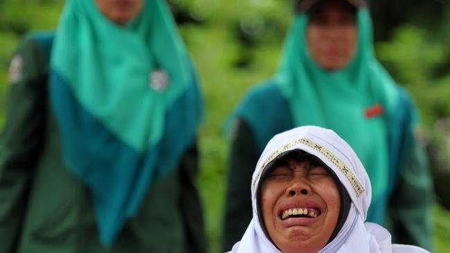 A Muslim woman cries out as she gets caned 23 strokes after being caught in proximity with her boyfriend in Banda Aceh in October last year. Picture: Chaideer Mahyuddin/AFP