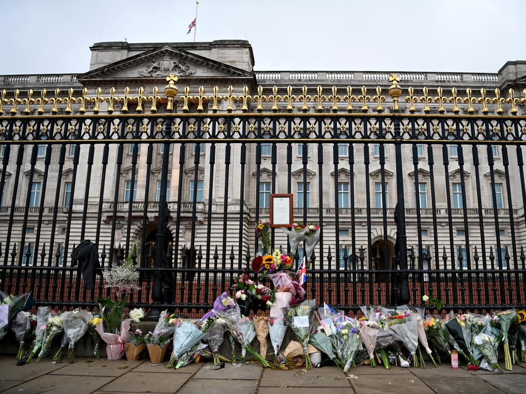 Flowers are placed alongside Queen's death notice on the gates of Buckingham Palace. Picture: Getty Images.