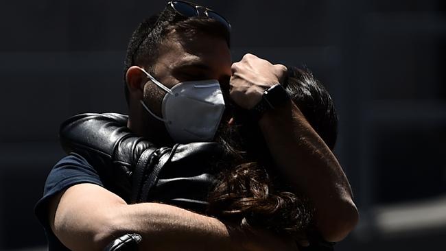 Travellers hug at Rome's Fiumicino airport on Thursday after airports and borders reopened for tourists and residents. Picture: AFP