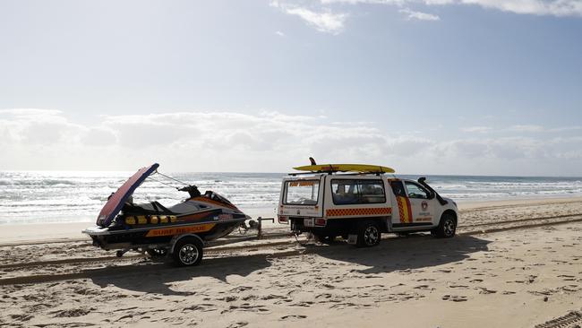 Surf Rescue crew drive past the scene where the body of an infant was found at Surfers Paradise on the Gold Coast.(AAP Image/Regi Varghese).