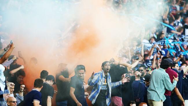 A flare is ignited in the Melbourne Victory supporters area of the crowd.