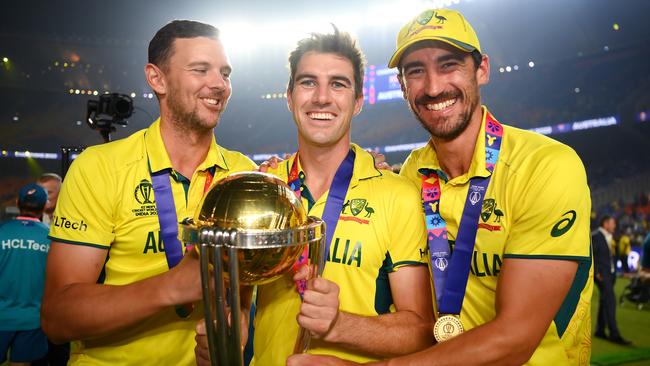 AHMEDABAD, INDIA - NOVEMBER 19: Josh Hazlewood, Pat Cummins and Mitchell Starc of Australia pose for a photo with the ICC Men's Cricket World Cup Trophy after  the ICC Men's Cricket World Cup India 2023 Final between India and Australia at Narendra Modi Stadium on November 19, 2023 in Ahmedabad, India. (Photo by Alex Davidson-ICC/ICC via Getty Images)