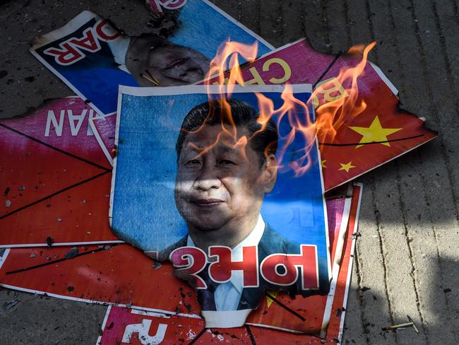 Members of National Students' Union of India (NSUI) burn a poster of Chinese President Xi Jinping during an anti-China demonstration in Ahmedabad on June 18, 2020. - India and China agreed on June 17 to ease tensions at their disputed Himalayan border, even as they traded blame for a brawl that left at least 20 Indian soldiers dead. (Photo by SAM PANTHAKY / AFP)