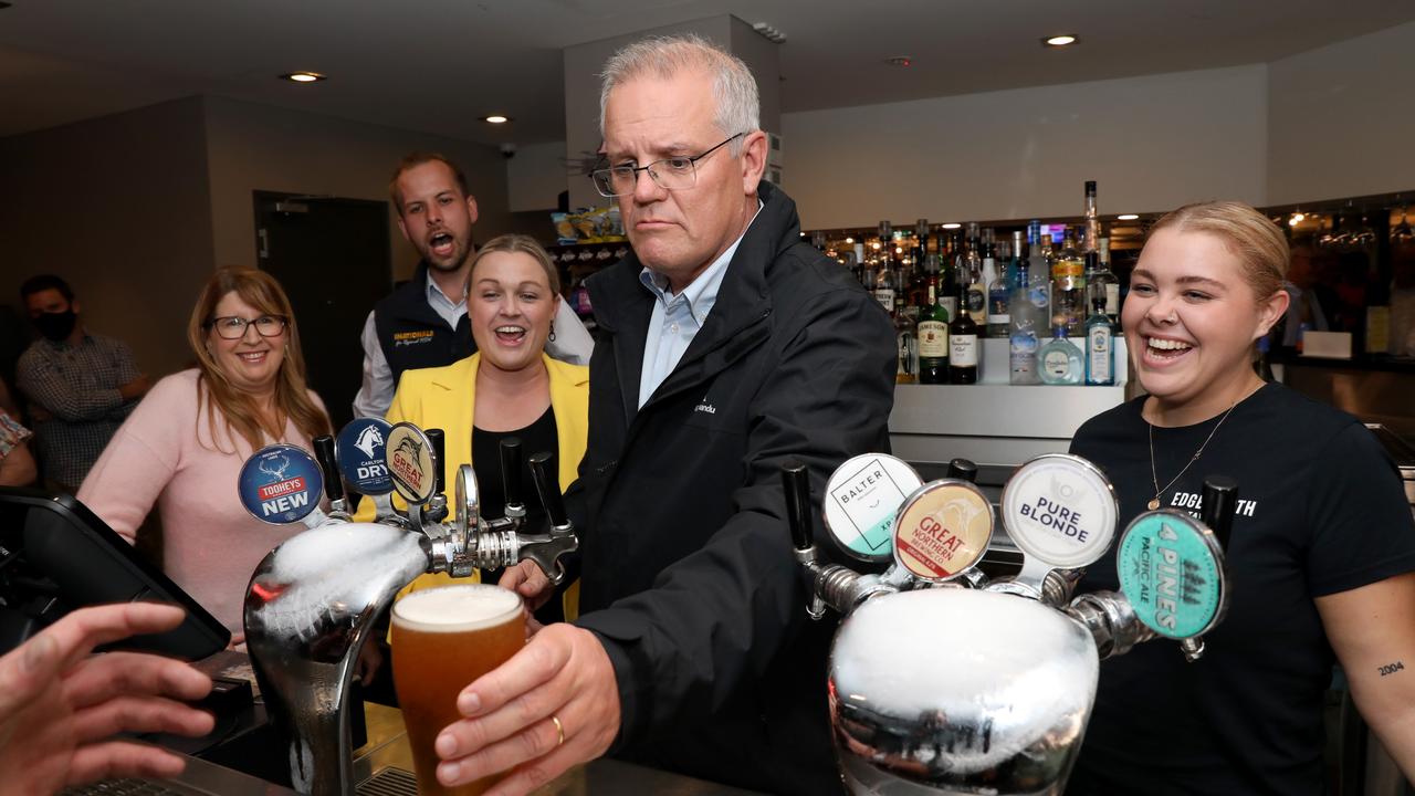 The PM also got behind the bar to pouring a few pints. Picture: Damian Shaw