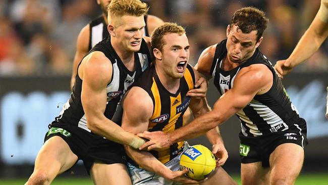 Tom Mitchell is tackled by Adam Treloar and Jarryd Blair.