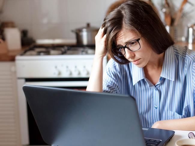 CORONAVIRUS: Picture: istock Upset woman working from home office. Worry freelancer using laptop and the Internet. Workplace in cozy kitchen. Concept of female business and career, housekeeping, stress. Lifestyle moment.