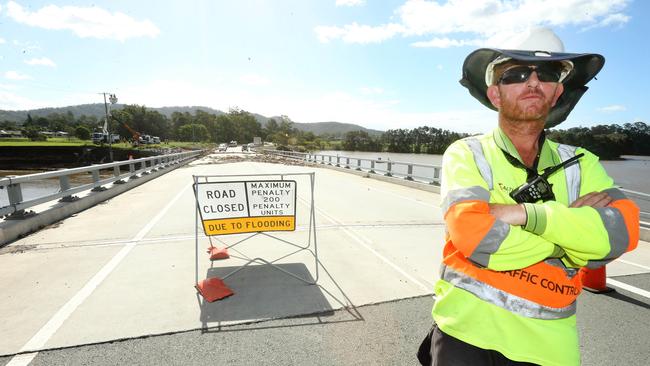 Altus Traffic controller Jamie McSkimming directing traffic at the John Muntz Bridge over the Coomera river at Oxenford. Picture: Mike Batterham