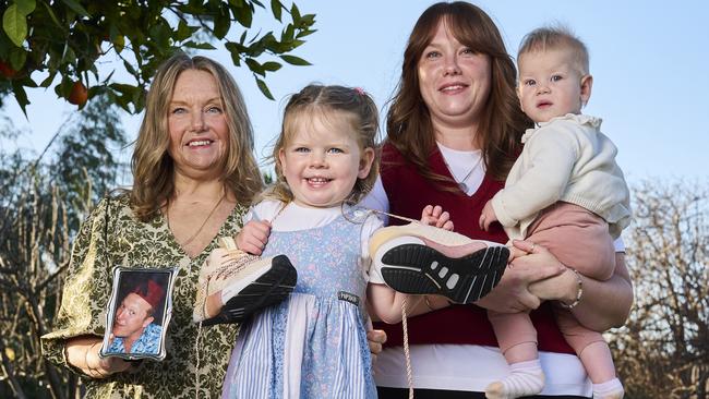 Angie Dimmock holding a picture of her late husband, Dean, with her daughter, Alyce Dimmock, and her granddaughters. Picture: Matt Loxton