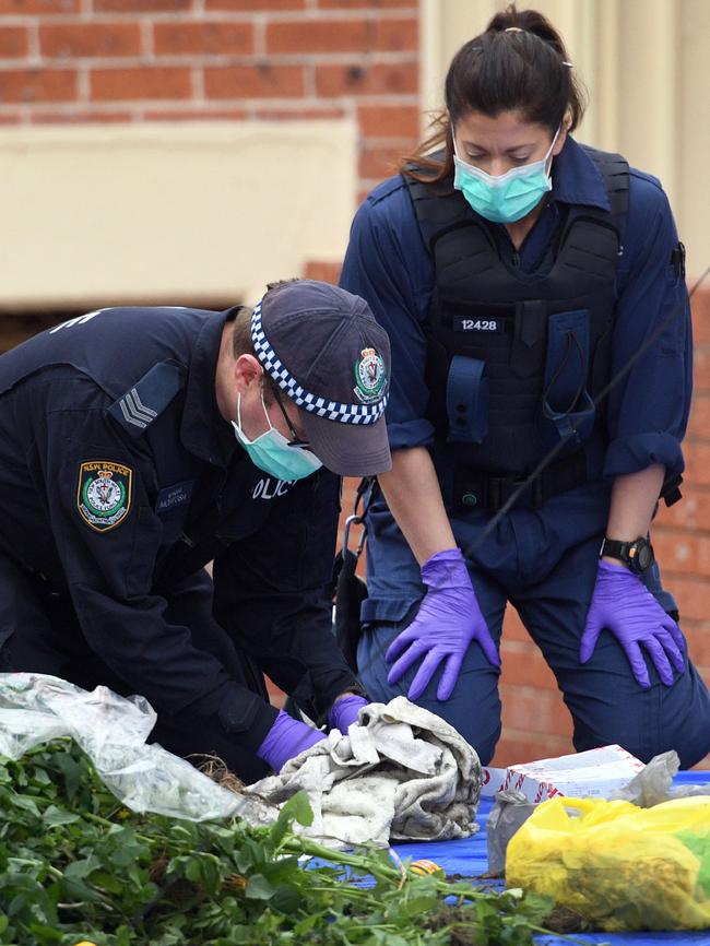 Police officers looking for evidence at a block of units in Lakemba following the arrests. Picture: AFP Photo/William West