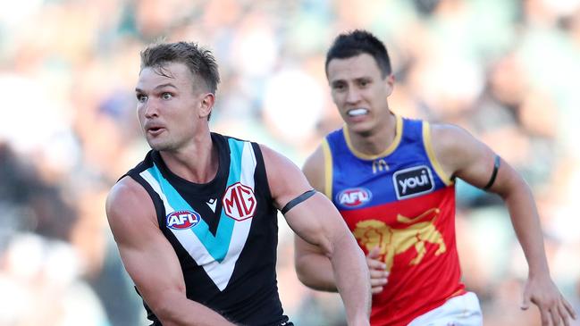 Ollie Wines powers away from Hugh McCluggage. Picture: Sarah Reed/AFL Photos via Getty Images