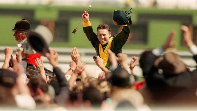 Chris Munce salutes the Flemington crowd as he returns to scale on Jezabeel after winning 1998 Melbourne Cup. Picture: Michael Dodge