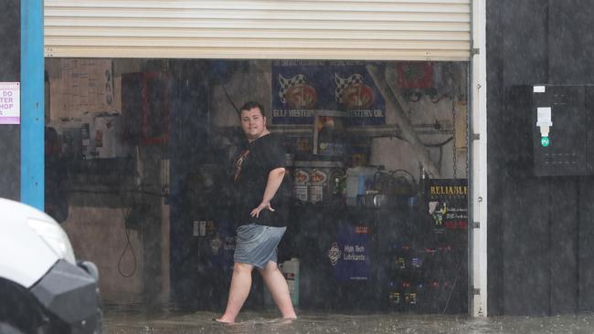 Major flooding in Currumbin Creek rd at Currumbin. Workers watch the crisis unfold in front of them. Picture Glenn Hampson