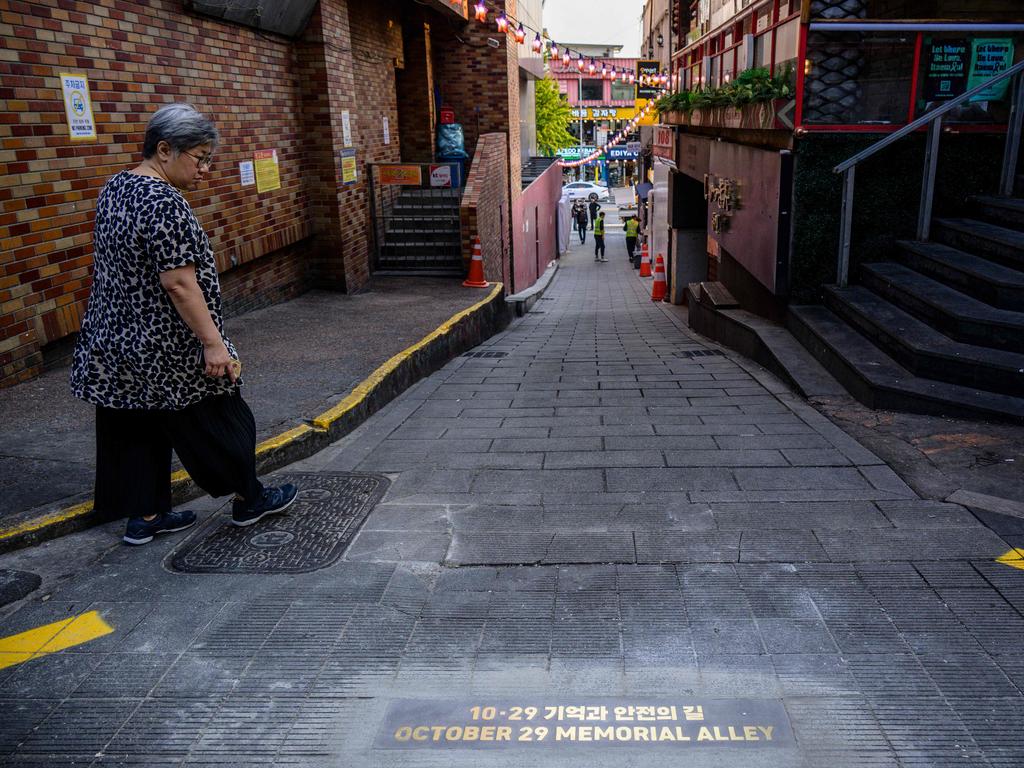 A woman walks past newly unveiled-lettering on October 25, 2023, that reads ‘October 29 Memorial Alley’ under Korean writing that translates as ‘Alley of Memories and Safety’, in memory of the victims. Picture: Anthony Wallace / AFP