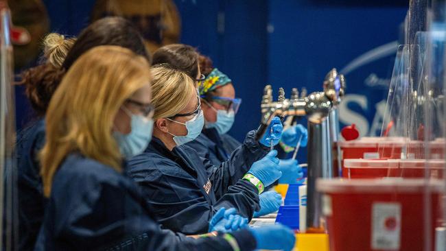 Nurses prepare syringes with doses of Covid-19 vaccine while working behind beer taps at Fenway Park in Boston. Picture: AFP