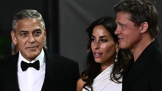 Actor George Clooney, Ines de Ramon and actor Brad Pitt arrive at the red carpet of the movie "Wolfs". Picture: AFP