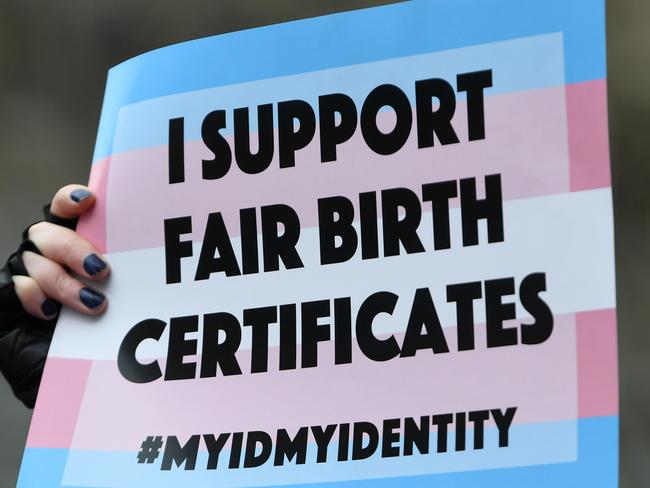 A placard held by a supporter of the gender diverse birth certificate bill is seen outside of the Victorian State Parliament in Melbourne, Wednesday, August 14, 2019. The bill, which allows Trans and gender diverse people to alter their birth certificate was introduced into parliament today. (AAP Image/James Ross) NO ARCHIVING