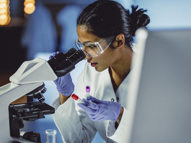 Young Scientist Looking Through a Microscope