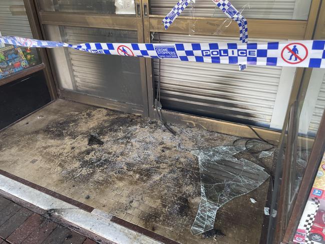 Police taped off the store's entrance and shattered glass from the windows were scattered. Picture: Jack Colantuono