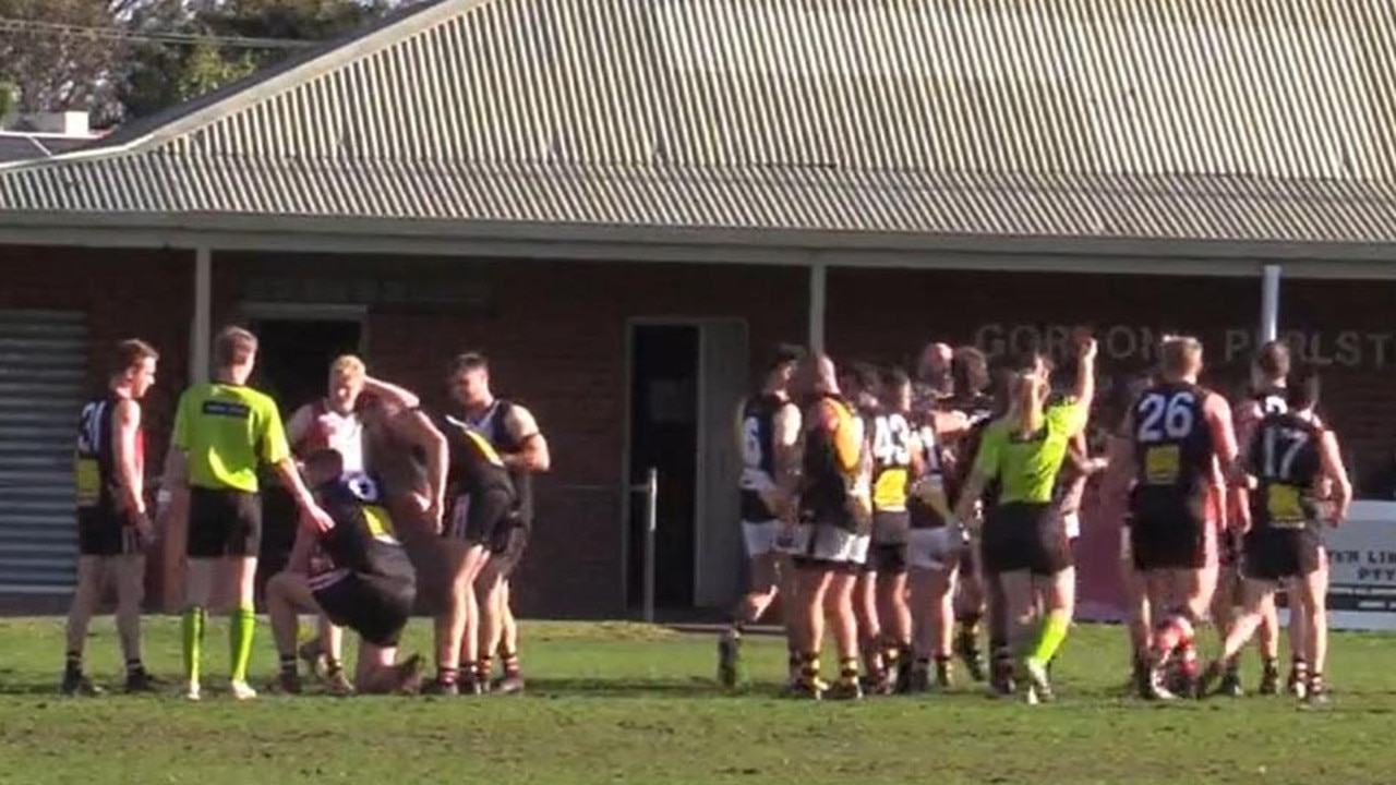 Westmeadows ruckman Ferras Mehri is red carded as Lynden Dunn (left) crouches over in pain.