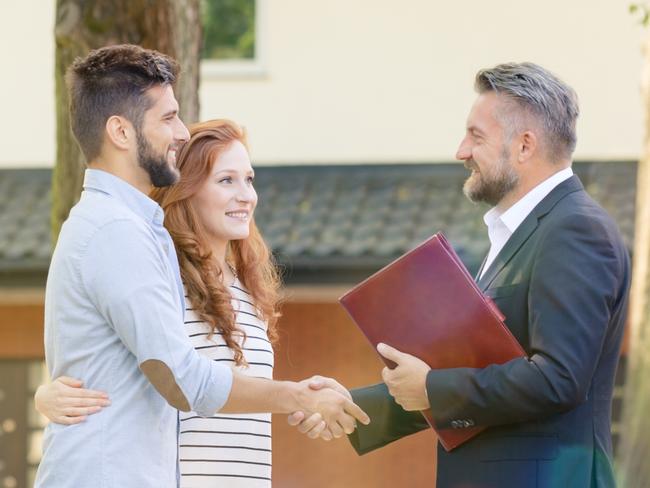 Real estate agent welcoming young visitors of open house for sale