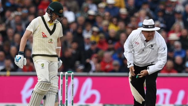 Umpire Marais Erasmus clutches a bail after it falls off the stumps. Picture: AFP