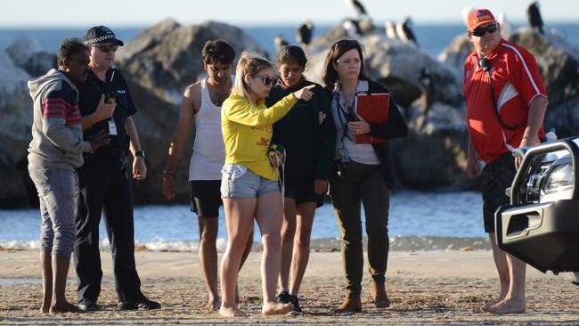 Rescuers look for a missing swimmer off the breakwater at Glenelg, Sunday, December 10, 2017. Up to four people were rescued and one is missing after getting into difficulty while swimming. (AAP Image/ Brenton Edwards)