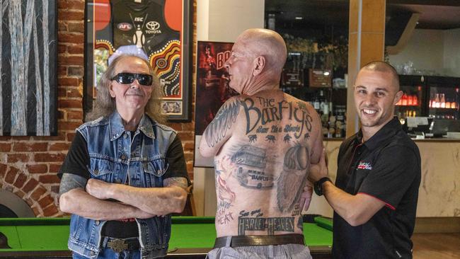 Barflyz super fan Sparky with his inked ode to the band he has followed, with band manager Mark Barton (left) and British Hotel Port Adelaide licensee Ash Coulls. Picture: Kelly Barnes