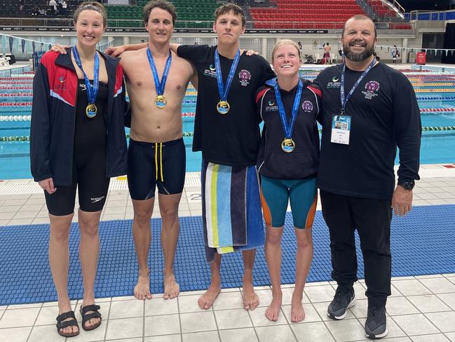 (Left to right) Georgina Seton, 21, Cameron McEvoy, 28, Joshua Kerr, 16 and Lillie McPherson 13, with coach Justin Rothwel,l after winning the Mixed 4x50m freestyle relay for the Manly Swimming Club at the Australian Shortcourse Swimming Championships at the Sydney Olympic Park Aquatic Centre on Thursday night. Picture: Manly Swimming Club