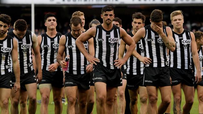 Collingwood players walk off after the loss to Carlton.