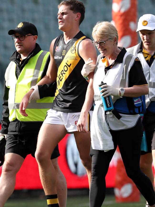 Tiger Carl Nicholson is helped from the field after copping a heavy knock against South Adelaide. Picture: Sarah Reed