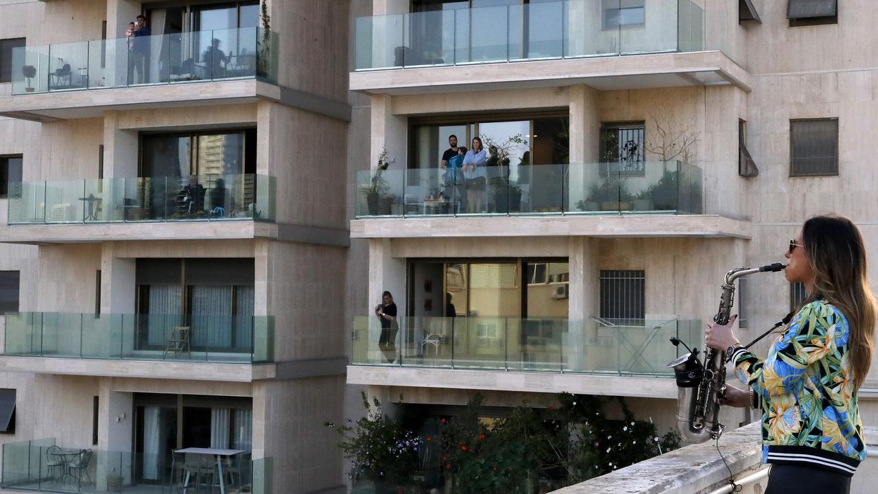 Saxophonist Yarden Klayman performing on a rooftop for residents of Basel Square in Tel Aviv after her concert was cancelled due to the COVID-19 novel coronavirus. Picture: Jack Guez/AFP