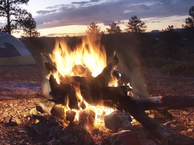 ESCAPE: Camping Etiquette, . A fire illuminates campsite at dawn. HDR used to bring out colors and detail throughout the image. . Picture: iStock