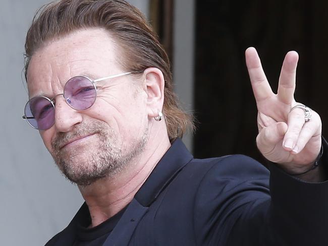 FILE - In this Monday, July 24, 2017 file photo, U2 singer Bono makes a peace sign as he arrives for a meeting at the Elysee Palace, in Paris, France. Leaked papers revealing investments in tax havens by the world's wealthy suggest U2 frontman Bono used a company based in low-tax Malta to buy part of a shopping mall in Lithuania, it was announced on Monday Nov. 6. (AP Photo/Michel Euler, file)