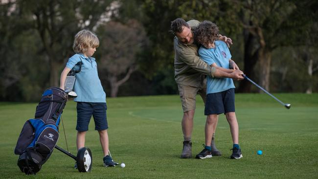 Justin Calvelrey tees off with his sons, Benjamin and Samuel. Picture: Jason Edwards