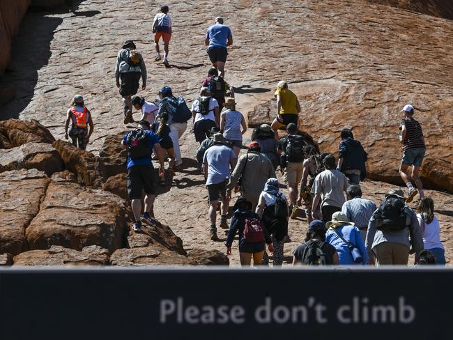 Tourists are seen climbing Uluru, also known as Ayers Rock at Uluru-Kata Tjuta National Park in the Northern Territory on the last day. Picture: AAP