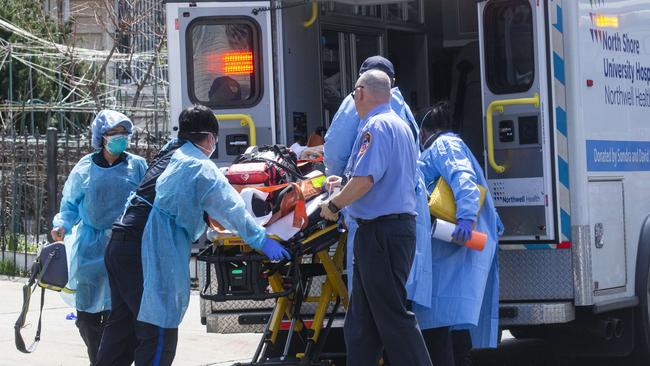 A patient is wheeled out of Elmhurst Hospital Centre in Queens, New York, to a waiting ambulance to be moved to another medical centre. Picture: Getty Images